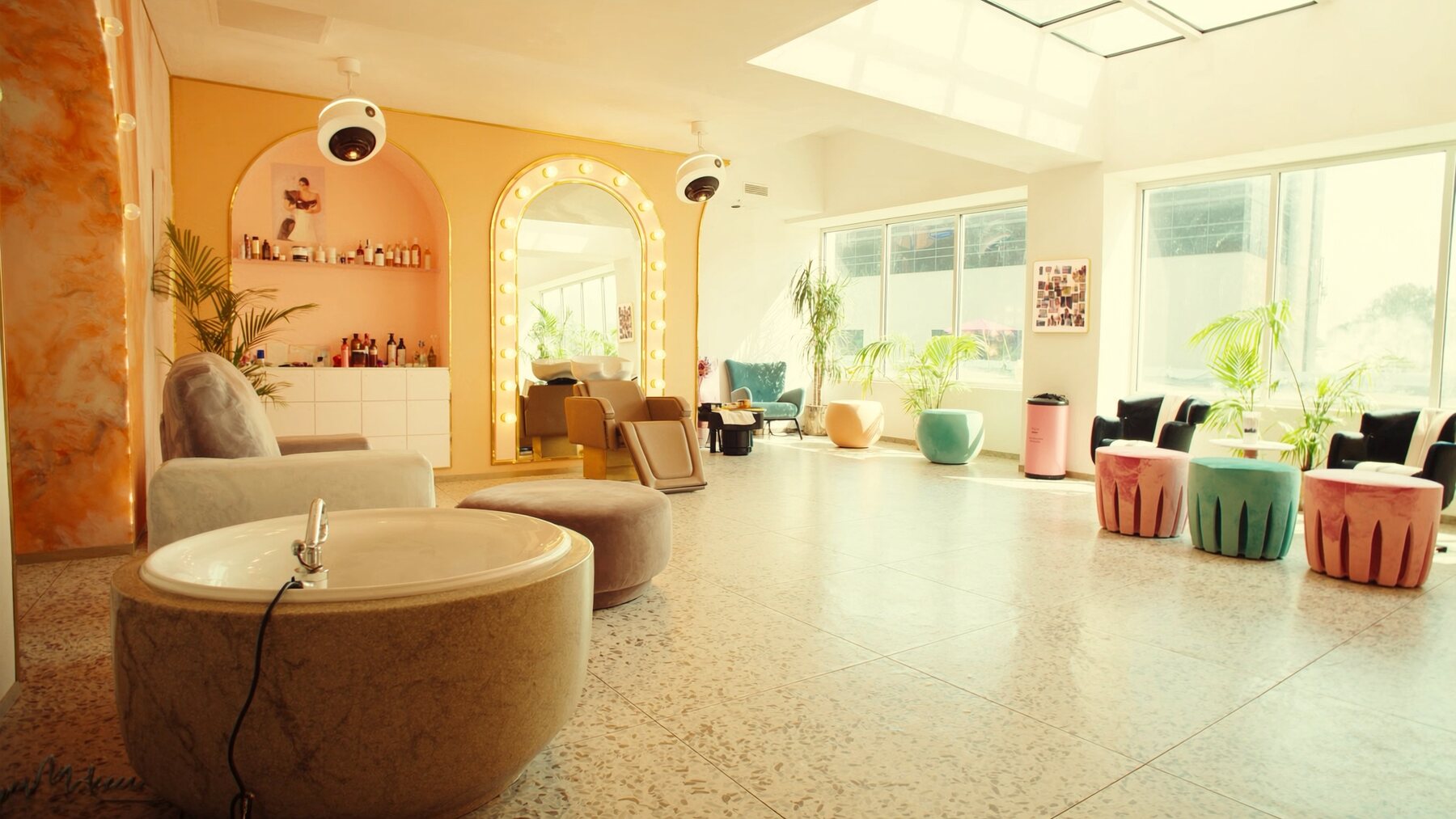 Bright salon interior with arched mirrors, terrazzo floor and pastel chairs